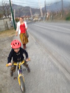 A blurry photo of a family trip to the grocery store - Levi's first on his bike.